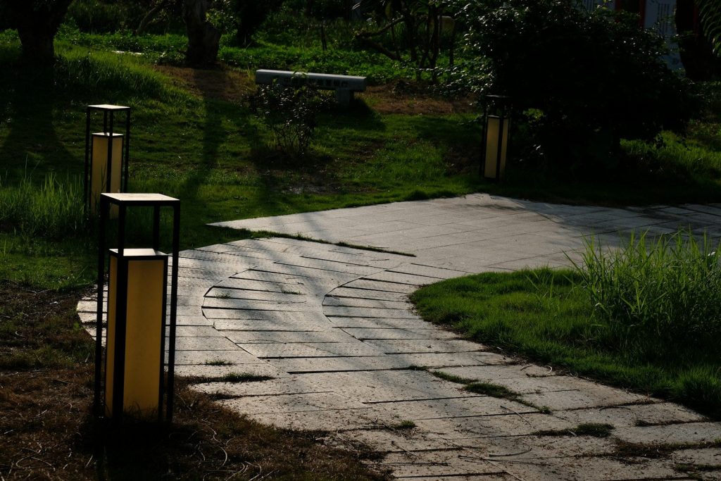 Lave bollardlamper langs en stenbelagt sti i skumring